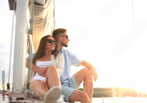 Attractive couple on a yacht enjoy bright sunny day on vacation.