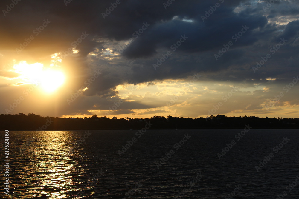 sun through clouds over water