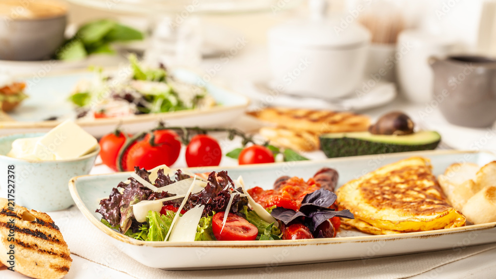 The concept of an Italian breakfast. omelette and salad. background image. Copy space, selective focus The concept of an Italian breakfast. omelette and salad. background image. Copy space, selective focus