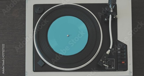 The male hand removes the needle from the vinyl record and stops the player. photo