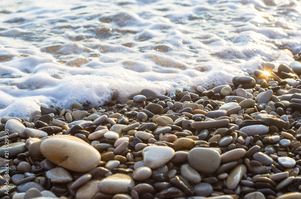 pebble stones on the sea beach, the rolling waves of the sea with foam pebble stones on the sea beach, the rolling waves of the sea with foam