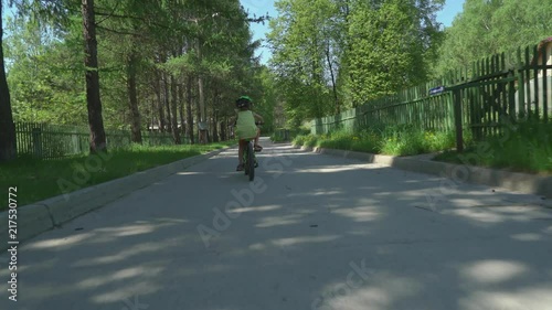 Wallpaper Mural Little boy in helmet riding bicycle in suburbs in sunny day. Torontodigital.ca