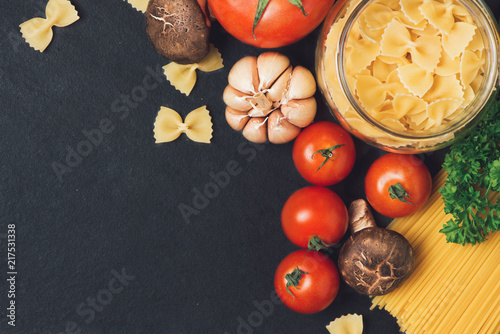 Italian food concept. Pasta ingredients. Cherry-tomatoes, spaghetti pasta, rosemary and spices