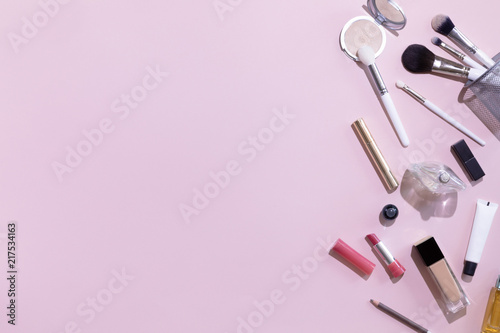 Flat lay and top view of make up products and cosmetics set on pink background with copyspace. Beauty concept for blogger, pastel women business office table desk