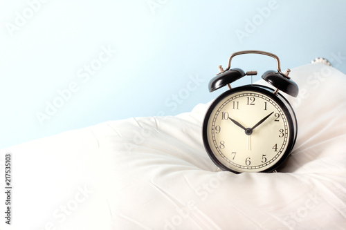 Alarm clock on the pillows. Advertising concept, copy space