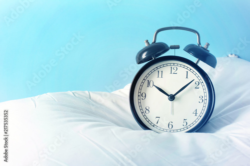 Alarm clock on the pillows. Advertizing concept, copy space