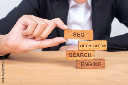 business hand building SEO concept with wooden blocks on wood, Search, engine, optimization, SEO