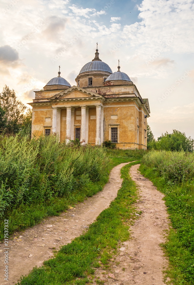 country road to the ancient Borisoglebsk cathedral at sunset in the ancient city of Staritsa