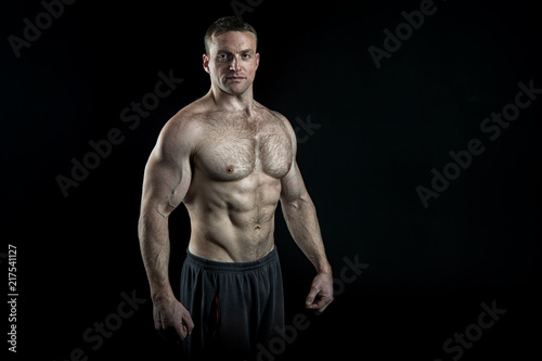 Pure perfection. Man bodybuilder posing with tense muscles on black background. Bodybuilder achieved best shape for muscles. Ready for championship. Bodybuilder perfect muscular body, copy space