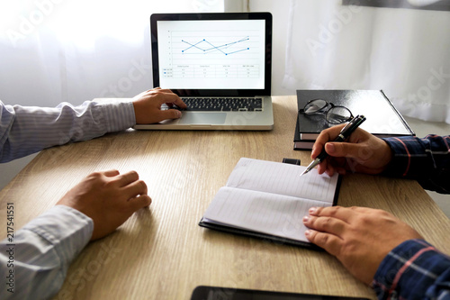 Businessman using laptop to teach and  analysis the situation on the market value , Business concept .