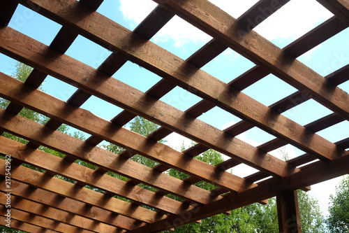 Leinwand Poster Top of brown wooden pergola on sunny summer day side view outdoor