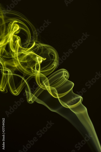 Yellow-green smoke on a black background and texture. Isolated colorful smoke in a studio space. Mystical artwork and shape.