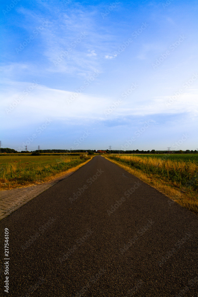 Long asphalt road with blue sky