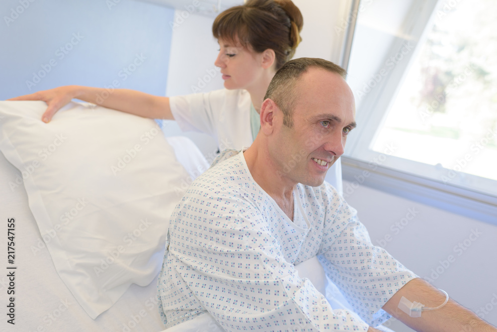 Obraz premium nurse helping patient in bed in hospital