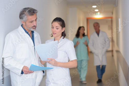 Nursing staff looking at paperwork in hospital corridor