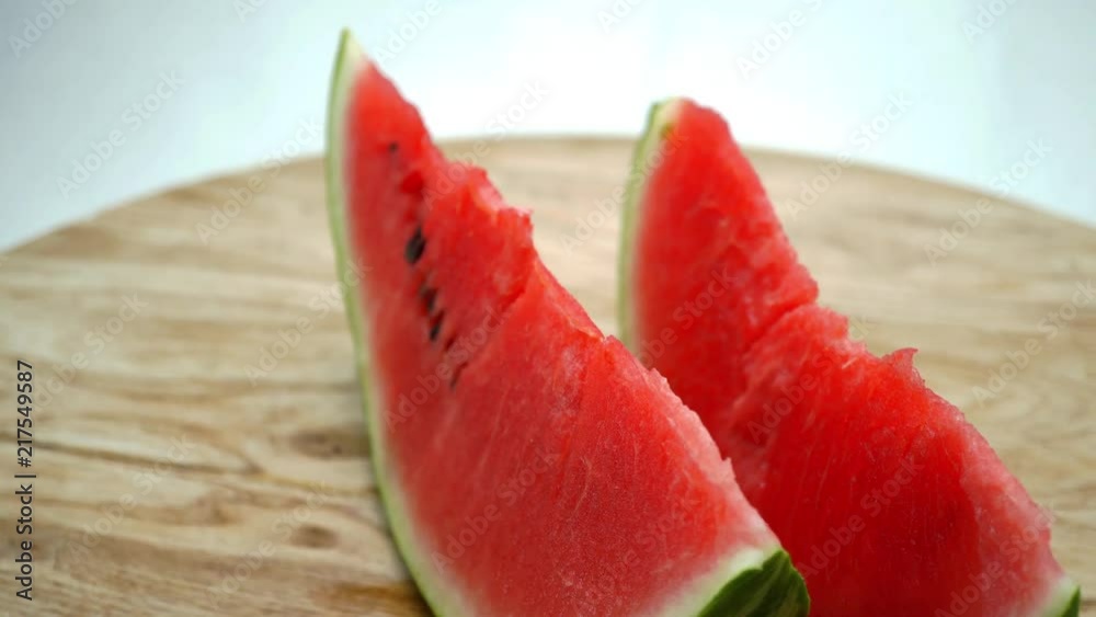 Organic fresh watermelon rotating on the wooden table. Macro. 4K Organic fresh watermelon rotating on the wooden table. Macro. 4K