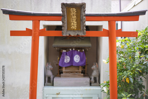 Shinto neighborhood sanctuary with torii portal dedicated to Inari fox deity in Komagome's Somei Ginza shopping street. photo