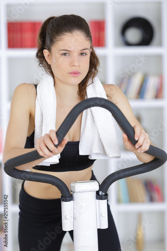 sporty woman training on step machine in bright living room