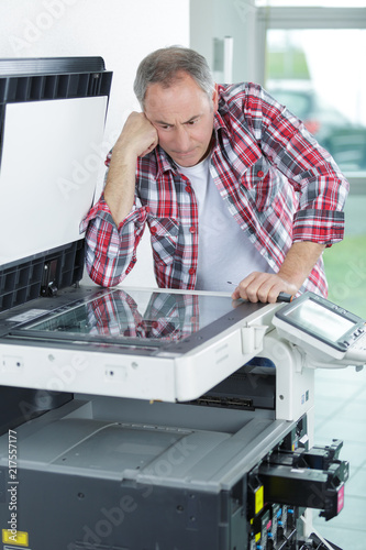 confused worker fixing a printer