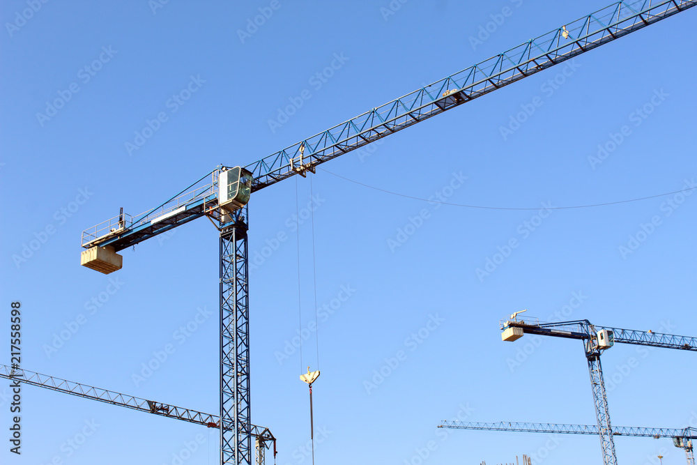 Large construction site including several cranes working on a building complex Large construction site including several cranes working on a building complex