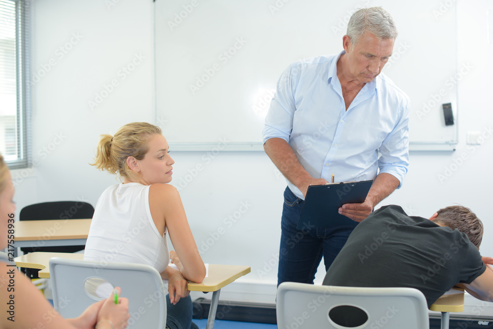 sleepy student and unhappy teacher in the classroom