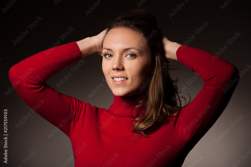 creaqtive portrait of a beautiful young caucasian happy woman in red wool kneeted sweater