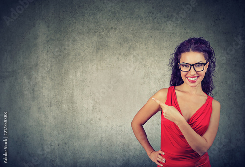 Elegant modern woman in dress pointing away