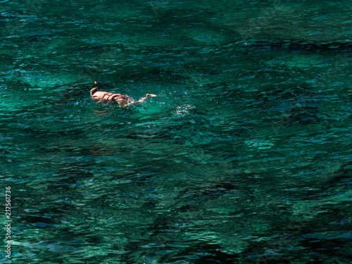 tourist with a mask in the emerald sea