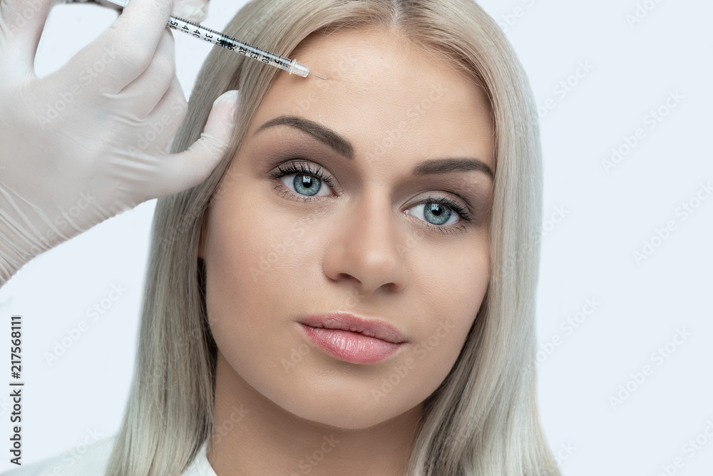 Women having cosmetic injection in the forehead. Woman in beauty procedure