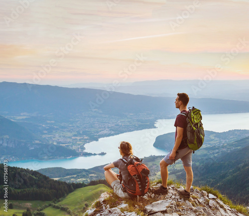 couple of hikers relaxing on top of mountain with beautiful panoramic view outdoors, two tourists backpackers during hike, adventure honeymoon © Song_about_summer