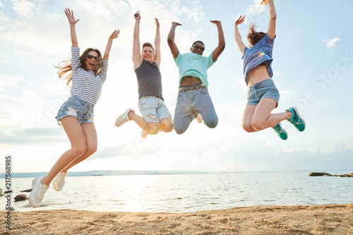 Portrait of excited young people jumping together and enjoying the summer