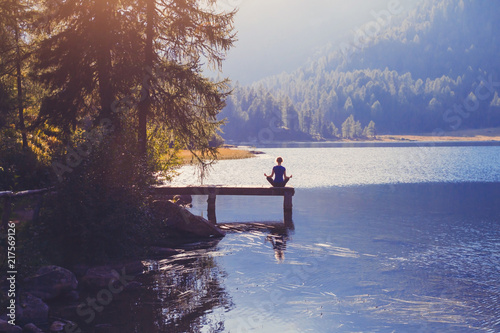 meditation and yoga practicing at sunset, breathe exercise background with silhouette of woman, calmness and harmony