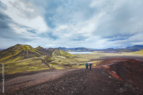 hiking in Iceland near Landmannalaugar, couple of backpackers walking in beautiful moon landscape, travel