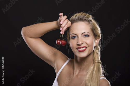 girl with cherry on a black background
