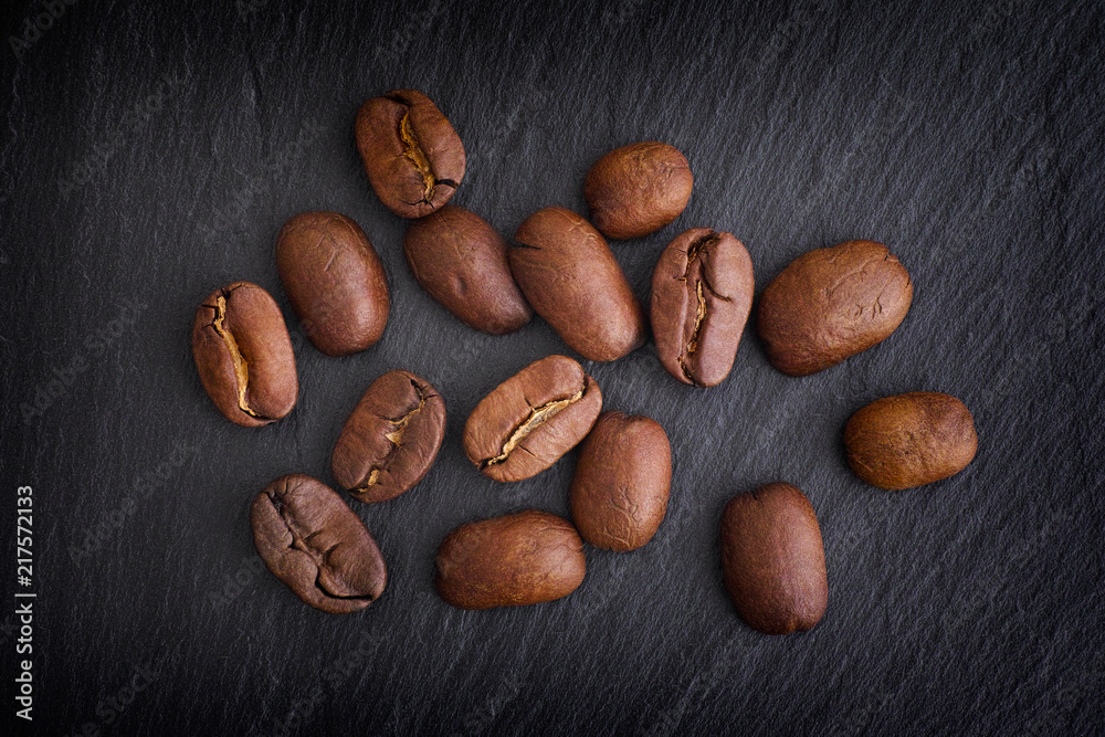 Obraz premium Coffee beans on black slate background