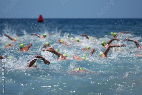 Triathlon swimmers in the open sea,view from behind