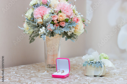 Wedding rings in the box and an unusual beautiful wedding bouquet on the table