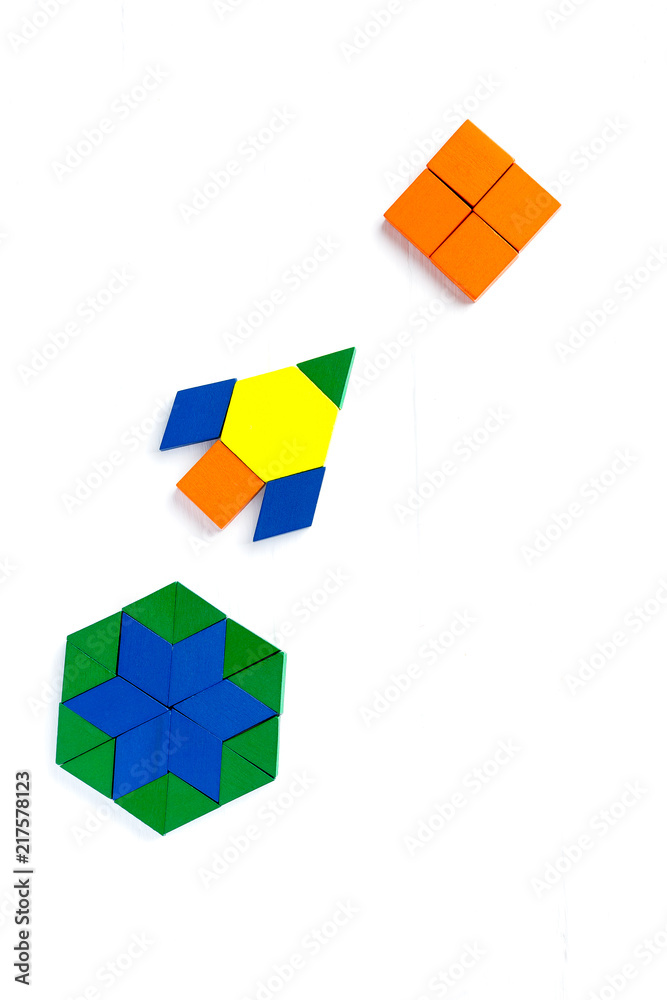 The space ship flies into space to another new planet. Summer happy atmosphere. A child plays with colored blocks constructs a model on a light wooden background. The space ship flies into space to another new planet. Summer happy atmosphere. A child plays with colored blocks constructs a model on a light wooden background.