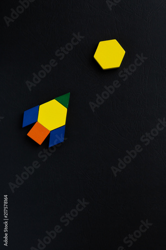 The space ship flies into space to another new planet. Summer happy atmosphere. A child plays with colored blocks constructs a model on a black background. photo