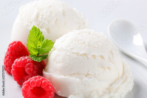 Scoops of white ice cream with raspberries