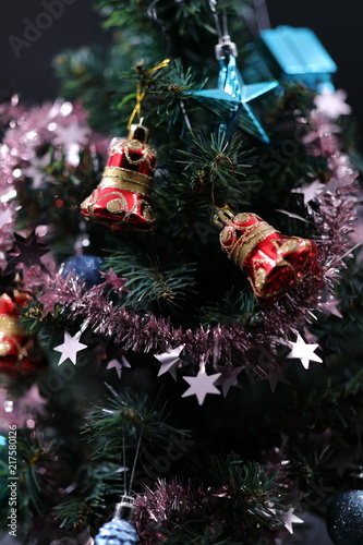The red and blue Christmas-tree decorations hanging on branches among brilliant tinsel.