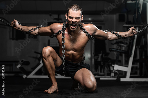 Muscular man slave in chains in gym, the prisoner © Vladimir