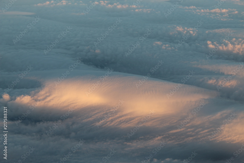Obraz premium Dense cloud wave partially lit by sunlight