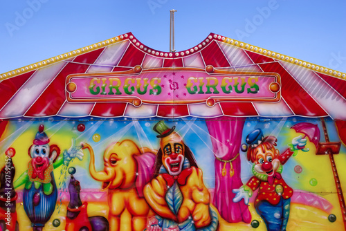 Entry facade of a circus against blue sky. Colorful facade of a circus attraction with drawings and lights