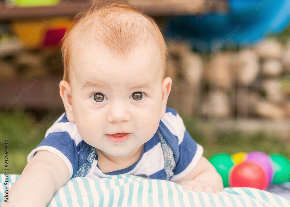 Happy adorable baby boy sitting on the grass and laughing. Happy adorable baby boy sitting on the grass and laughing.