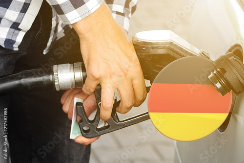 The flag of Germany on the lid of the gas tank with a filling gun inserted into it