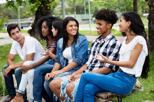 Native latin american woman and african man talking with caucasian friends outdoor in the summer in the city photo