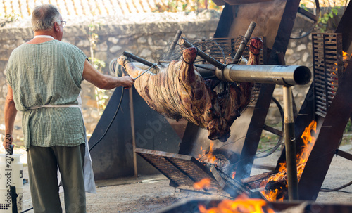 Chef cooking on fire whole bull carcass