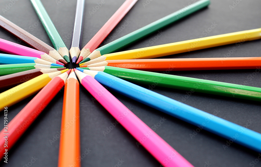 colorful bright pencils lie all around on a black background colorful bright pencils lie all around on a black background