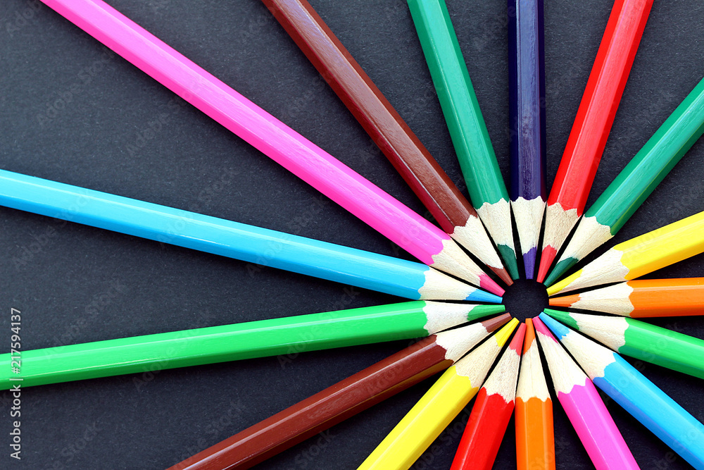 colorful bright pencils lie all around on a black background colorful bright pencils lie all around on a black background
